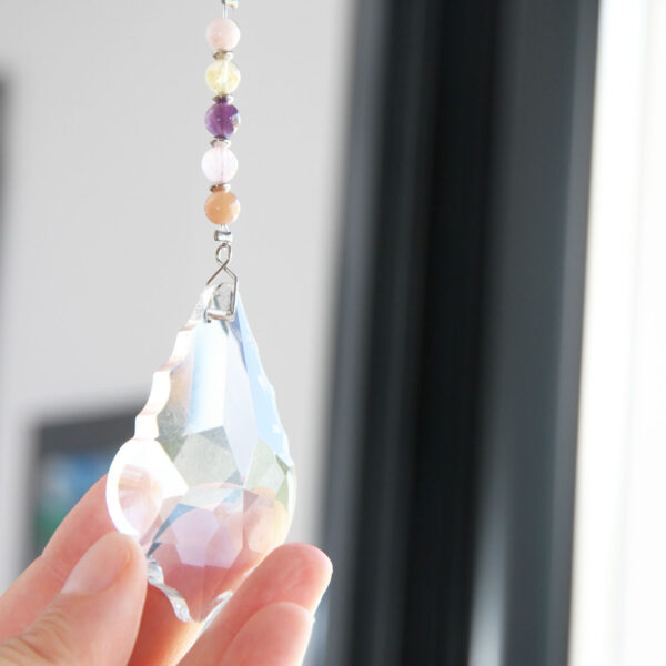 Suncatcher avec cristal et perles naturelles, fabriqué à la main, pour diffuser des reflets arc-en-ciel et créer une ambiance apaisante.
